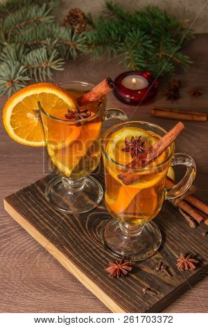 Two Glasses With Delicious Fragrant Tea Of Mulled Wine With Orange And Spices On A Wooden Board With