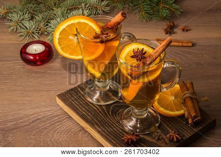 Two Glasses With Delicious Fragrant Tea Of Mulled Wine With Orange And Spices On A Wooden Board With