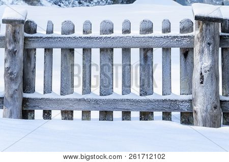 Winter At Countryside With A Snowy Old Wooden Fence, Surrounded By A Thick Layer Of Snow, On A Sunny