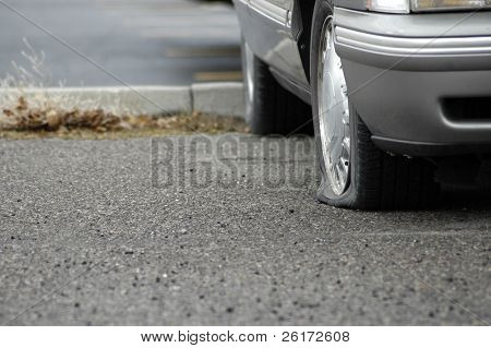 Auto parcheggiata su una carreggiata con una gomma a terra