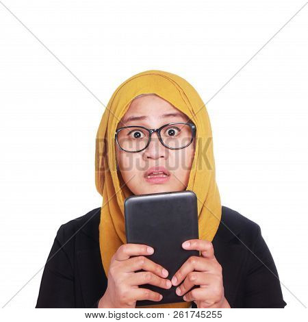 Young Asian Businesswoma Wearing Suit And Hijab Shocked Expression Holding A Tablet, Surprised Expre