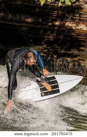 Munich, Germany - Sept 8, 2018: A Man Surfing In The Waves Of The Eisbach River In Downtown Of Munic