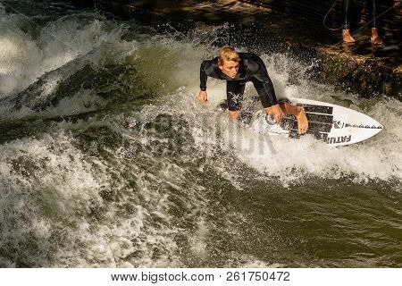 Munich, Germany - Sept 8, 2018: A Man Surfing In The Waves Of The Eisbach River In Downtown Of Munic