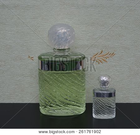 Fragrance For Ladies, Large Perfume Bottle Next To A Commercial Perfume Bottle In Front Of The Satin