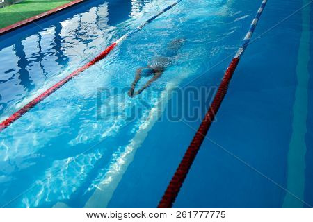 Image of sportsman swimming on path in pool