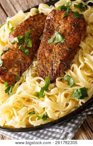 New Orleans Chicken Lazone Fried With Spices And Fettuccine Pasta In A Creamy Sauce Close-up. Vertic