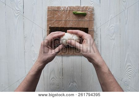 Process of making maki sushi. Cook chef hands preparing rolls with cheese, avocado and sesame seeds 
