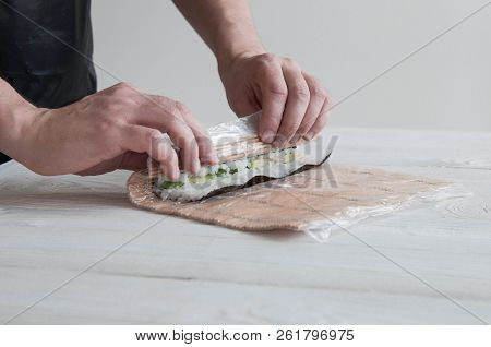 Process Of Making Maki Sushi. Cook Chef Hands Preparing Rolls With Cheese, Avocado And Sesame Seeds 