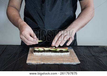 Process Of Making Maki Sushi. Cook Chef Hands Preparing Rolls With Cheese, Avocado And Sesame Seeds 