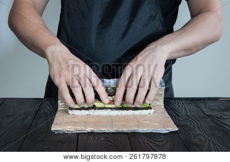 Process Of Making Maki Sushi. Cook Chef Hands Preparing Rolls With Cheese, Avocado And Sesame Seeds 
