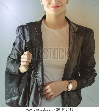 Portrait Of Beautiful Young Brunette Woman In Stylish Black Jacket On Gray.