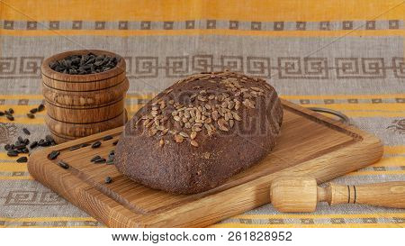 Fresh Whole Grain Bread With Seeds On A Wooden Board, Mortar With Sunflower Seeds. Rye Bread With Su