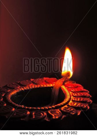 Close Up Isolated Low Key Diwali Oil Clay Lamp,chirag Or Panti On A Dark Orange Black Background Wit