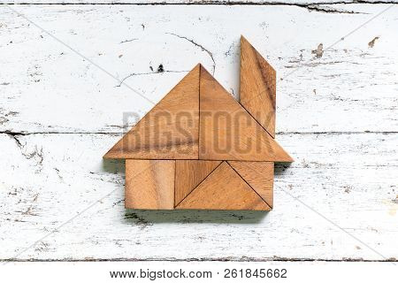 Tangram Puzzle In Home Shape On Old White Wood Background
