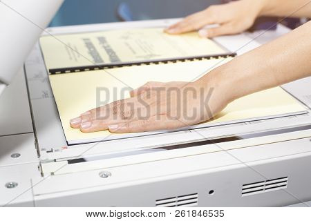 Woman Hands Putting A Sheet Of Paper Into A Copying Device