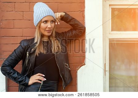 Young Attractive Lady In Blue Knitting Hat Stay Under  Brick House, Look Away. Smiling Beautiful Hip