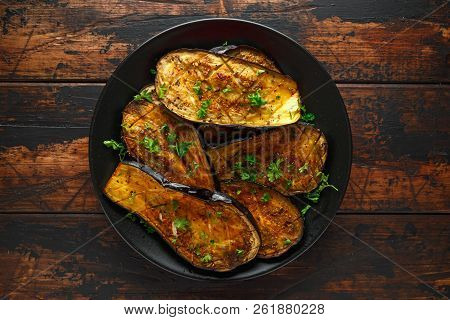 Healthy Vegeterain Oven Baked Aubergines, Eggplant With Parsley And Herbs In A Black Plate