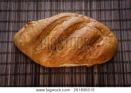 Bun On A Straw Brown Litter.
Freshly Baked Loaf Of Bread On A Straw Mat.