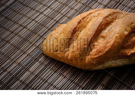 Bun On A Straw Brown Litter.
Freshly Baked Loaf Of Bread On A Straw Mat.