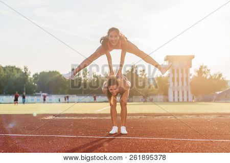 Fit Women At The Stadium Playing Leap Frog.