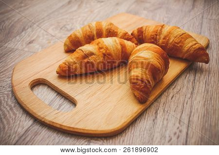 A Rich Variety Of Food Photography Croissant.
Four Croissants On A Wooden Light Cutting Board On A W