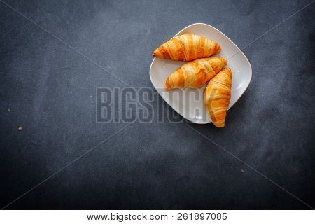 Delicious Croissants On A Square White Plate On Dark Craft Paper.