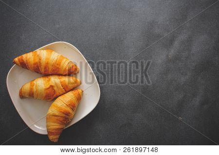 Delicious Croissants On A Square White Plate On Dark Craft Paper.