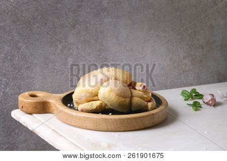 Raw Organic Uncooked Whole Yellow Corn Mini Chicken On Wooden Cutting Board With Salt, Herbs And Gar