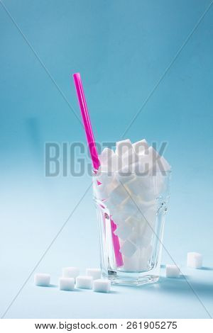 Sugar Cubes In Glass, Diabetes And Sugar Overuse Concept, Blue Background With Copy Space