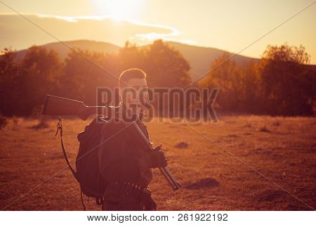 Rifle Hunter Silhouetted In Beautiful Sunset. Autumn Hunting Season. Autunm Hunting