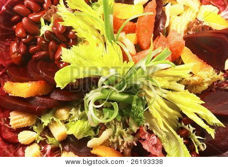 Un insalata di barbabietola con fagioli rossi, lollo rosso, lattuga verde, mais ecc.