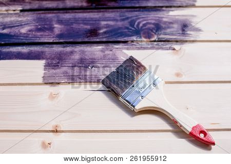 Half Painted Wooden Surface. Deep Black Color. Varnishing Natural Wood With Paint Brush.paint Wooden