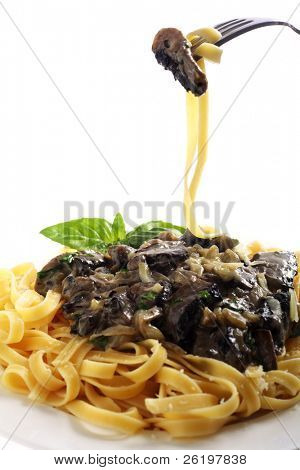 Un repas de fettuccini aux champignons, l'oignon et l'ail dans une sauce crème et le persil, servis avec un sp