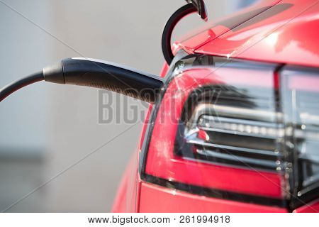 Red Electric Vehicle Plugged In 1