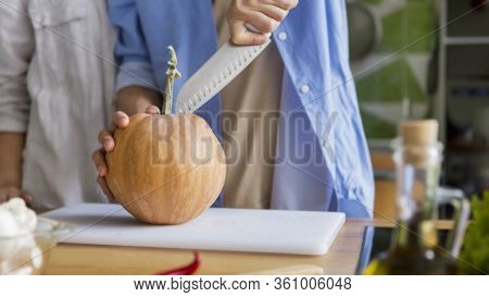 Vegetarian Man Chopping Pumpkin On A Board For Cooking Vegetarian Dessert, Panorama, Copy Space