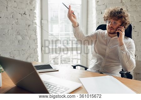 Talking On Phone. Caucasian Young Man In Business Attire Working In Office. Young Businesswoman, Man