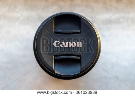 Brecht, Belgium - Februari 1 2020: A Close Up Portrait Of A Canon Lens Cap Lying On A Stone Tablet. 