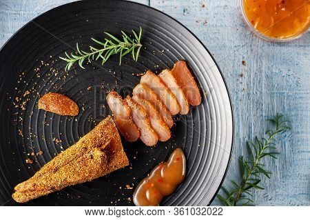 Seasoned Chicken With Hot Sauce And A Sprig Of Rosemary