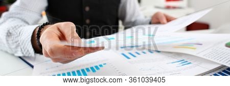 Close-up Of Businessman Working With Papers In Office. Documents With Graphs And Diagrams. Monthly R