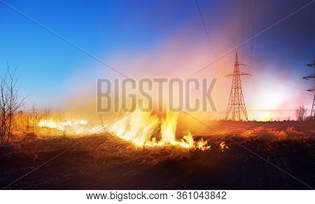 The Fire In The Field Is Orange And Red Hot And Dangerous, Its Flame With Heat And Poisonous Smoke H