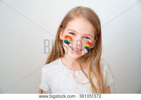 Little Girl With Blond Hair And Painted Cheeks A Rainbow. Stay Home. Flashmob Chasetherainbow.
