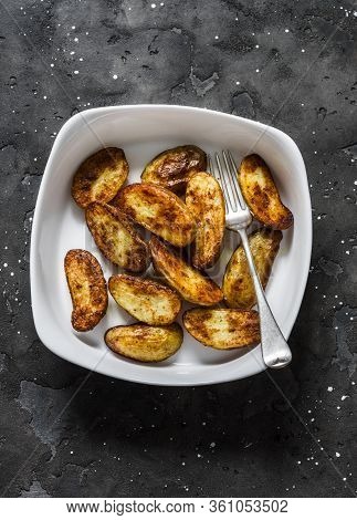 Roasted New Potatoes In Baking Dish On A Dark Background, Top View. Delicious Snack, Tapas