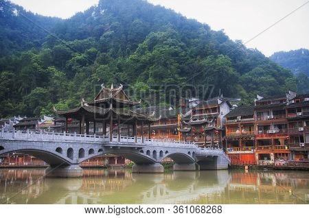 Fenghuang, China.  September 13, 2015.  A Chinese Bridge Over The Tuojiang River Leading To Business