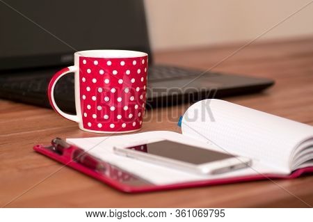 Workingat Home - Computer And Notebok With Teacup. Cup Of Cappuccino And Notebook Near Phone And Lap