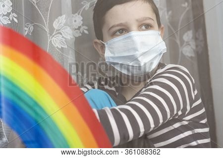 Masked Boy Is Looking Out The Window, The Window Is A Rainbow. End Of Quarantine. The Concept Of The