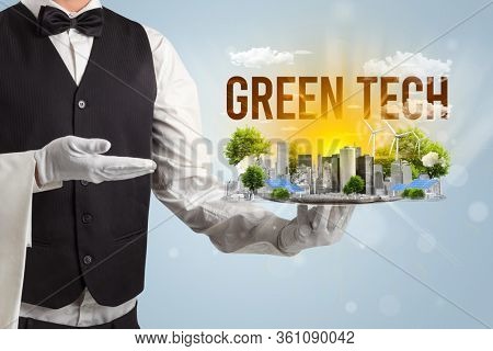 Waiter serving eco city with GREEN TECH inscription, renewabke energy concept