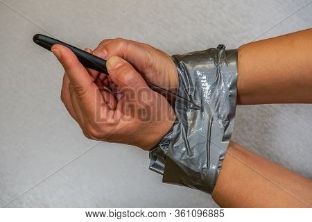 Trying To Tear Duct Tape And Escape From Tied Hands Survival Concept. Female Holds A Knife And Attem