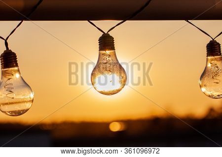 Vintage Light Bulbs On A The Sunset Background - Solar Power Concept
