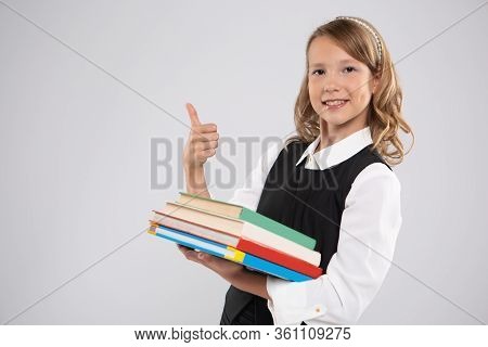 Girl Schoolgirl Writes On The Board With Red Chalk.
