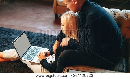 Lovely Couple Working At Home With A Computer And Embracing Each Other In The Living Room